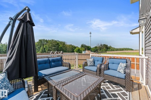 Spacious outdoor deck featuring wood-finish flooring and white railings - 12383 176 Avenue Nw, Edmonton, AB - Outdoor With Deck Patio Veranda With Exterior