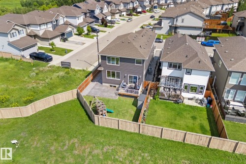 Rear elevation of a two-story residence featuring a ground-level patio with a wooden deck - 12383 176 Avenue Nw, Edmonton, AB - Outdoor