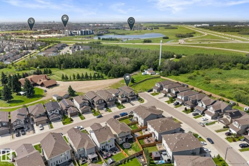 Aerial perspective showcasing a residential street with detached homes, surrounded by green spaces and a distant urban landscape - 12383 176 Avenue Nw, Edmonton, AB - Outdoor With View