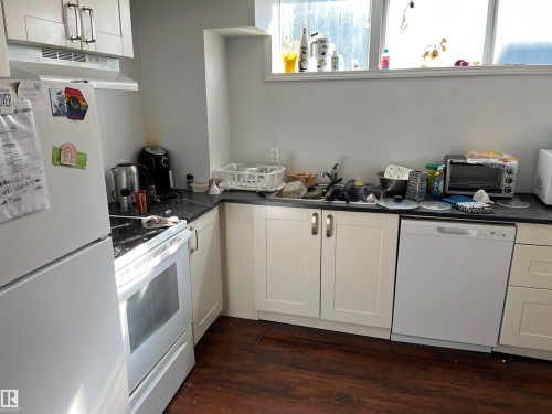 Efficient kitchen featuring white cabinetry, black countertops, and stainless steel appliances including a gas range and dishwasher - 12011 87 Avenue Nw, Edmonton, AB - Indoor Photo Showing Kitchen