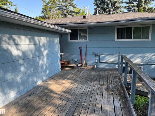 Wood-finish decking surrounds the property, featuring a built-in railing and visible siding - 12011 87 Avenue Nw, Edmonton, AB - Outdoor With Deck Patio Veranda