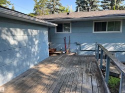 Wood-finish decking surrounds the property, featuring a built-in railing and visible siding - 