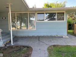Covered patio featuring stamped concrete flooring with mature landscaping and privacy fencing - 