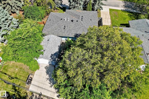 Gable roof home with an attached garage, paved driveway, and mature landscaping - 12011 87 Avenue Nw, Edmonton, AB - Outdoor