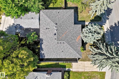 Property featuring a grey shingle roof, established landscaping, and a paved driveway - 12011 87 Avenue Nw, Edmonton, AB - Outdoor