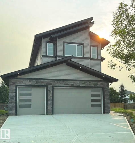 Contemporary two-story residence with a multi-pitched roofline and a concrete driveway - 34 Mckenzie Close Close, Leduc, AB - Outdoor With Exterior