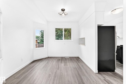 Spacious room featuring light wood-finish flooring and multiple windows providing natural illumination - 5519 142 Avenue Nw, Edmonton, AB - Indoor Photo Showing Other Room