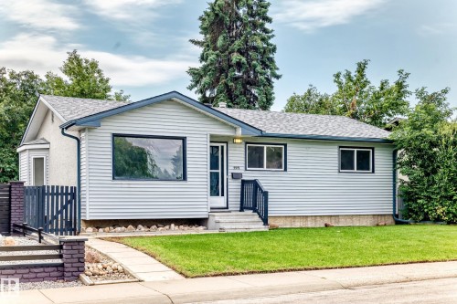 Light-colored siding exterior with a contrasting dark trim roofline - 5519 142 Avenue Nw, Edmonton, AB - Outdoor