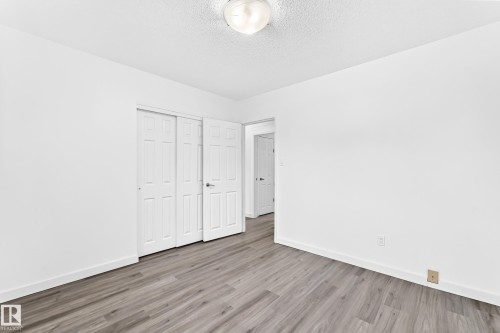 Room featuring wood-finish flooring, white walls, and a white baseboard trim - 5519 142 Avenue Nw, Edmonton, AB - Indoor Photo Showing Other Room