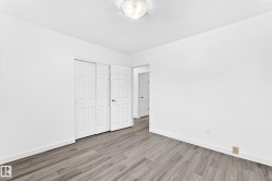 Room featuring wood-finish flooring, white walls, and a white baseboard trim - 