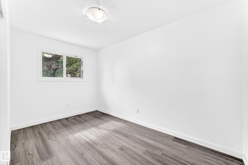 Bright room with white painted walls and wood-finish flooring - 5519 142 Avenue Nw, Edmonton, AB - Indoor Photo Showing Other Room