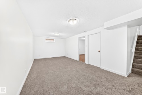 Carpeted room with white walls, two flush-mount ceiling lights, and a single window - 5519 142 Avenue Nw, Edmonton, AB - Indoor Photo Showing Other Room
