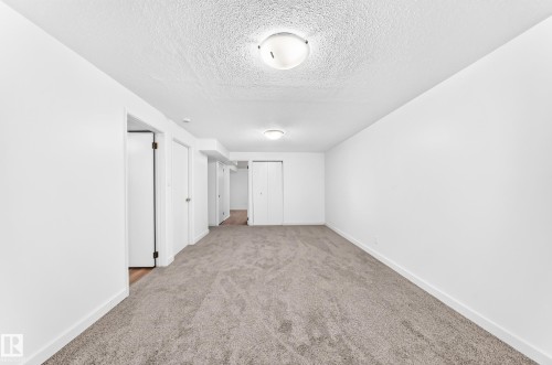 Neutral-toned wall-to-wall carpeting complements the white walls and trim - 5519 142 Avenue Nw, Edmonton, AB - Indoor Photo Showing Other Room