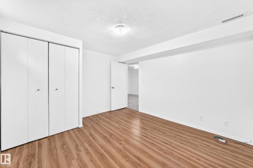 Room featuring wood-finish flooring, white walls, and a textured ceiling - 5519 142 Avenue Nw, Edmonton, AB - Indoor Photo Showing Other Room