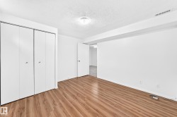 Room featuring wood-finish flooring, white walls, and a textured ceiling - 