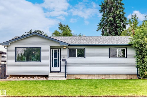 Single-story residence featuring light-colored horizontal siding, a gray shingle roof, and dark trim accents - 5519 142 Avenue Nw, Edmonton, AB - Outdoor