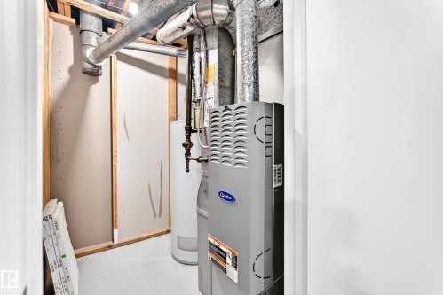 Utility closet featuring a water heater and furnace with exposed ductwork and framing - 5519 142 Avenue Nw, Edmonton, AB - Indoor Photo Showing Basement