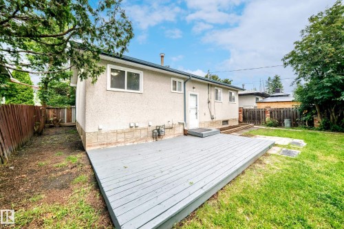 Expansive backyard featuring a gray-painted wood deck, a manicured lawn, and mature trees - 5519 142 Avenue Nw, Edmonton, AB - Outdoor With Exterior