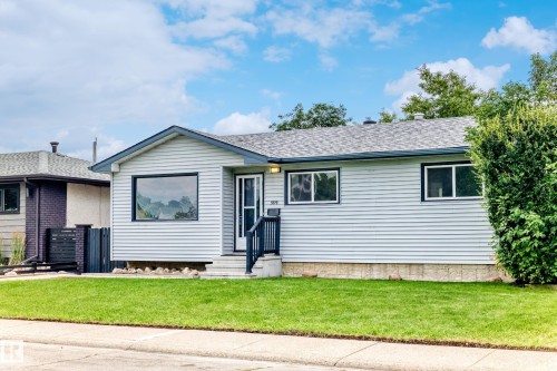 Exterior featuring light-colored horizontal siding, a gabled roof, and a prominent front window with dark trim - 5519 142 Avenue Nw, Edmonton, AB - Outdoor