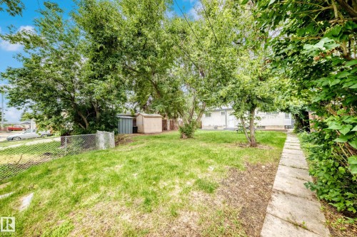 Expansive grassy backyard featuring mature trees providing ample shade - 5519 142 Avenue Nw, Edmonton, AB - Outdoor