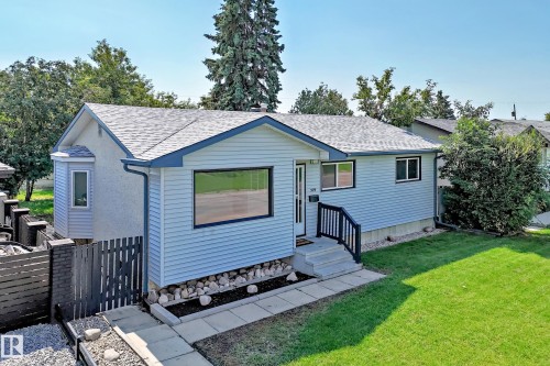 Light blue siding exterior featuring black trim windows - 5519 142 Avenue Nw, Edmonton, AB - Outdoor With Exterior