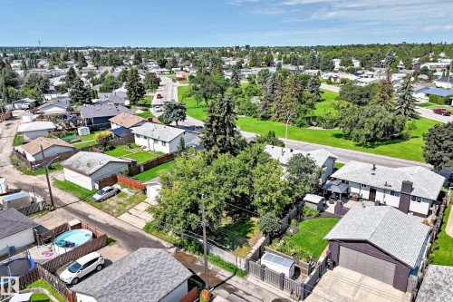 Aerial perspective showcasing a residential neighborhood with detached homes, mature trees, and green spaces - 5519 142 Avenue Nw, Edmonton, AB - Outdoor With Deck Patio Veranda