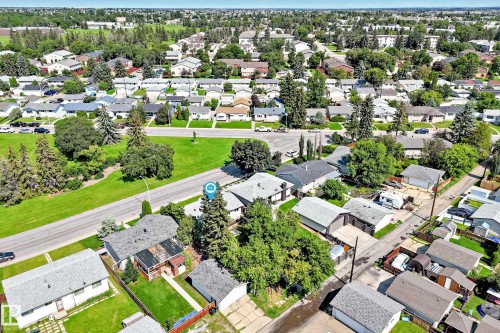 Aerial view showcasing a residential area with single-story homes, mature trees, and paved roads - 5519 142 Avenue Nw, Edmonton, AB - Outdoor With View