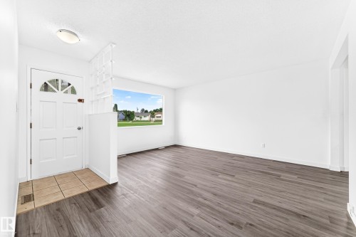 Entryway featuring a white door with an arched window, tile flooring, and a decorative partition - 5519 142 Avenue Nw, Edmonton, AB - Indoor Photo Showing Other Room
