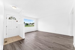 Entryway featuring a white door with an arched window, tile flooring, and a decorative partition - 