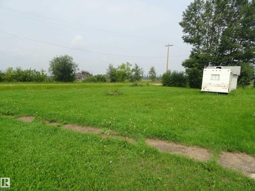 Expansive green lawn with established trees and natural foliage - 5140 51 Avenue, Vilna, AB 