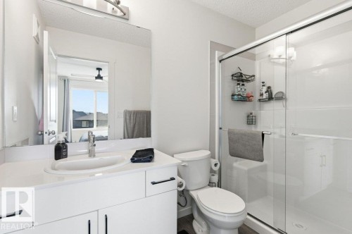 Modern primary bathroom featuring a floating white vanity with dual sinks, quartz countertop, and chrome fixtures - #49 850 Secord Bv Nw, Edmonton, AB - Indoor Photo Showing Bathroom