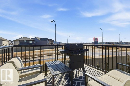 Outdoor patio space featuring black metal railings and a patterned area rug - #49 850 Secord Bv Nw, Edmonton, AB - Outdoor
