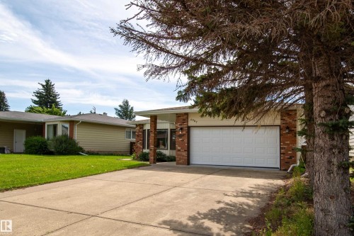 Ranch-style exterior featuring brick accents, horizontal siding, an attached garage, and a concrete driveway - 6907 19 Avenue Nw, Edmonton, AB - Outdoor With Facade