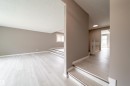 Split-level interior featuring contemporary light wood-finish flooring, neutral wall tones, and white trim throughout - 6907 19 Avenue Nw, Edmonton, AB  - Indoor Photo Showing Other Room 