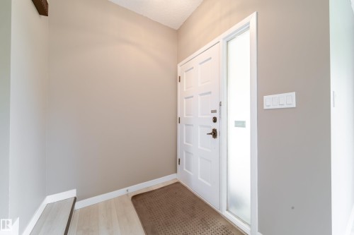 Entryway featuring a paneled door with a frosted sidelight, light wood-finish flooring, and neutral wall tones - 6907 19 Avenue Nw, Edmonton, AB - Indoor Photo Showing Other Room