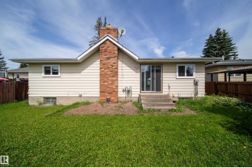 Charming single-story residence featuring cream-colored siding, a prominent brick chimney, and a composition roof - 6907 19 Avenue Nw, Edmonton, AB - Outdoor
