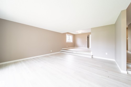 Spacious interior featuring light-toned wood-finish flooring and neutral wall tones - 6907 19 Avenue Nw, Edmonton, AB - Indoor Photo Showing Other Room