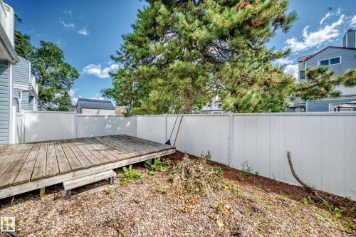 Private fenced backyard featuring a composite deck, gravel landscape base, and mature trees providing natural shade - 290 Lancaster Terrace Nw, Edmonton, AB - Outdoor