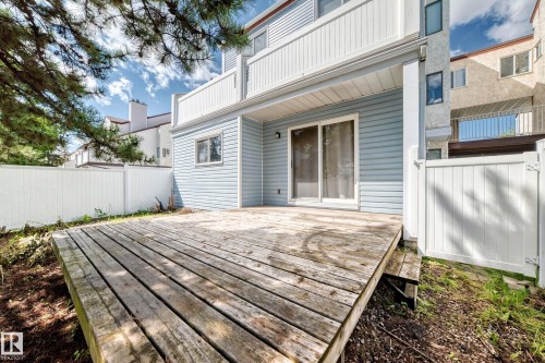Private wooden deck with sliding glass door access, light blue siding, and white perimeter fencing - 290 Lancaster Terrace Nw, Edmonton, AB - Outdoor With Deck Patio Veranda