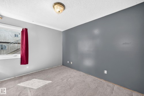 Spacious room featuring light gray carpet flooring, a window with white trim, and a ceiling-mounted light fixture - 290 Lancaster Terrace Nw, Edmonton, AB - Indoor Photo Showing Other Room