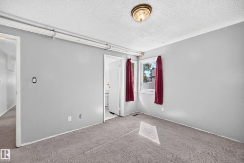 Carpeted interior space featuring light gray walls and a textured ceiling - 290 Lancaster Terrace Nw, Edmonton, AB - Indoor Photo Showing Other Room