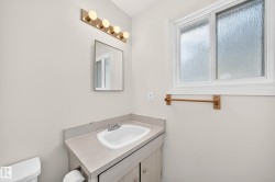 Bathroom vanity with integrated sink, laminate countertop, and wood-finish cabinetry - 