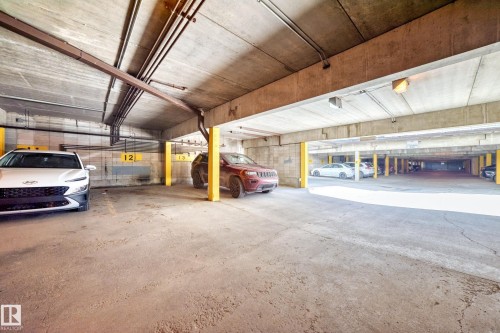 Spacious parking structure with multiple vehicle spaces, reinforced yellow support columns, and polished concrete flooring throughout - 290 Lancaster Terrace Nw, Edmonton, AB - Indoor Photo Showing Garage