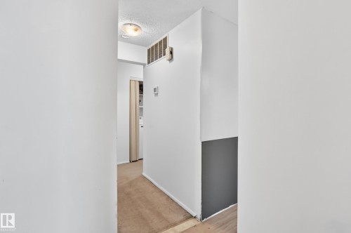 Hallway featuring light-colored carpet, a ceiling-mounted light fixture, and a white wall with a gray lower section - 290 Lancaster Terrace Nw, Edmonton, AB - Indoor Photo Showing Other Room