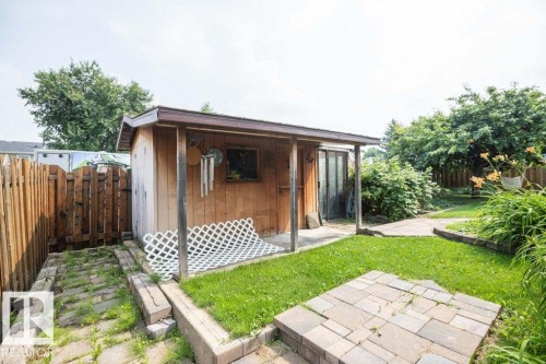 Wood-sided shed with an attached covered porch and a dark-framed window - 10711 108 Avenue, Westlock, AB - Outdoor With Deck Patio Veranda