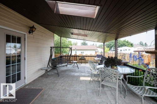 Expansive covered patio featuring a stamped concrete surface, a panelized ceiling, and direct access through a glass-paned door - 10711 108 Avenue, Westlock, AB - Outdoor With Deck Patio Veranda With Exterior