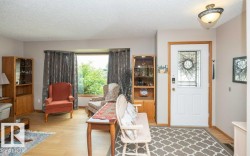 Entryway featuring a white paneled door with decorative glass insert, wood-finish flooring, and a flush-mount light fixture - 