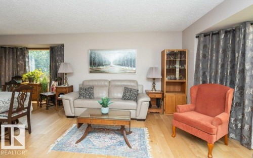 Living area featuring light wood-finish flooring, neutral wall tones, and recessed window openings - 10711 108 Avenue, Westlock, AB - Indoor Photo Showing Living Room