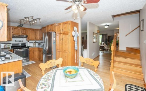 Kitchen featuring wood cabinetry, stainless steel appliances, granite-style countertops, and a subway tile backsplash - 10711 108 Avenue, Westlock, AB - Indoor