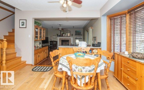 Bright dining area featuring hardwood flooring - 10711 108 Avenue, Westlock, AB - Indoor Photo Showing Dining Room With Fireplace